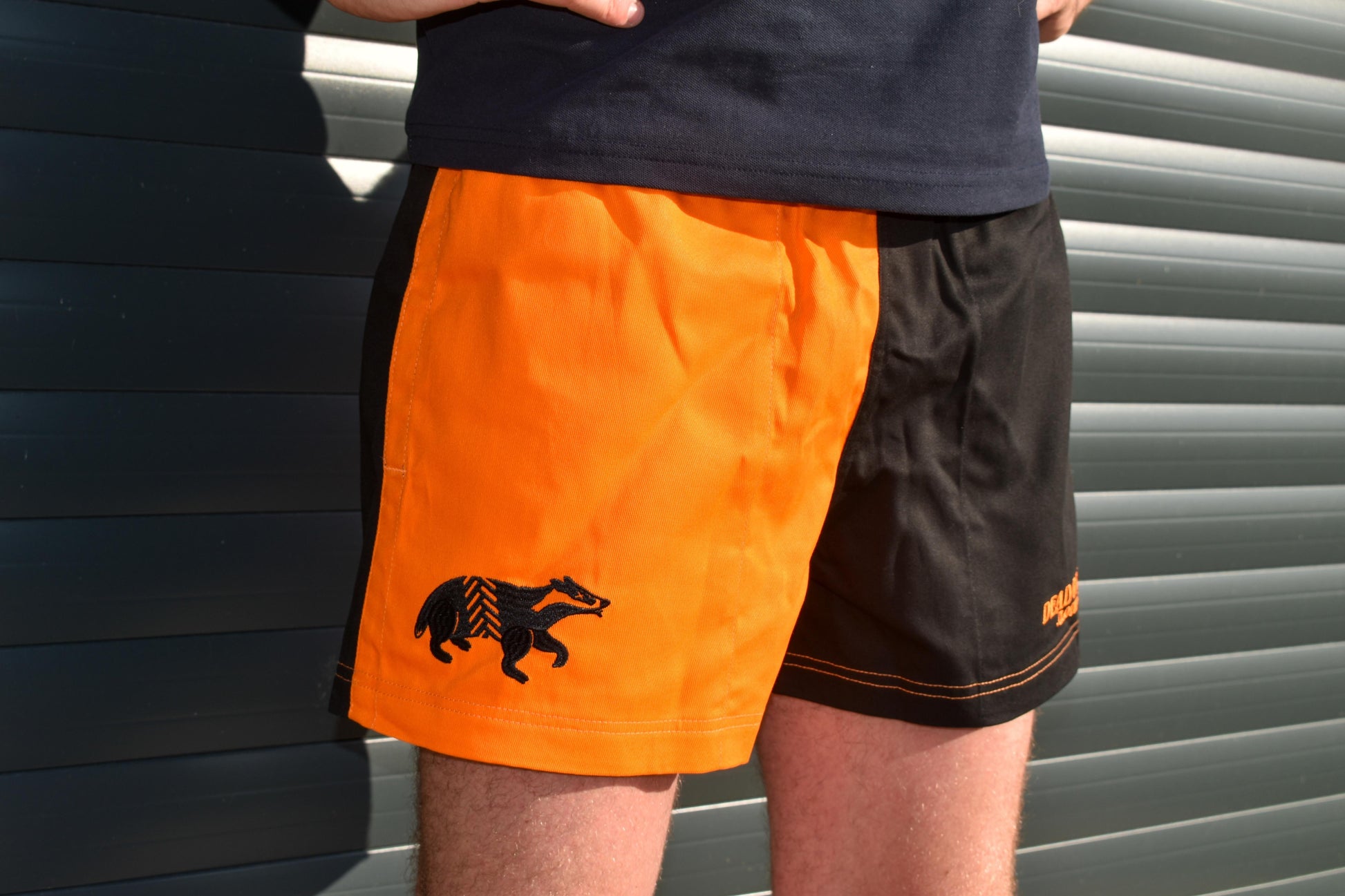 Dead Badger Clothing black and orange shorts close up
